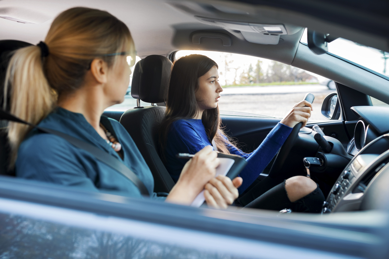 Photo: teen driver taking a road test with an instructor.