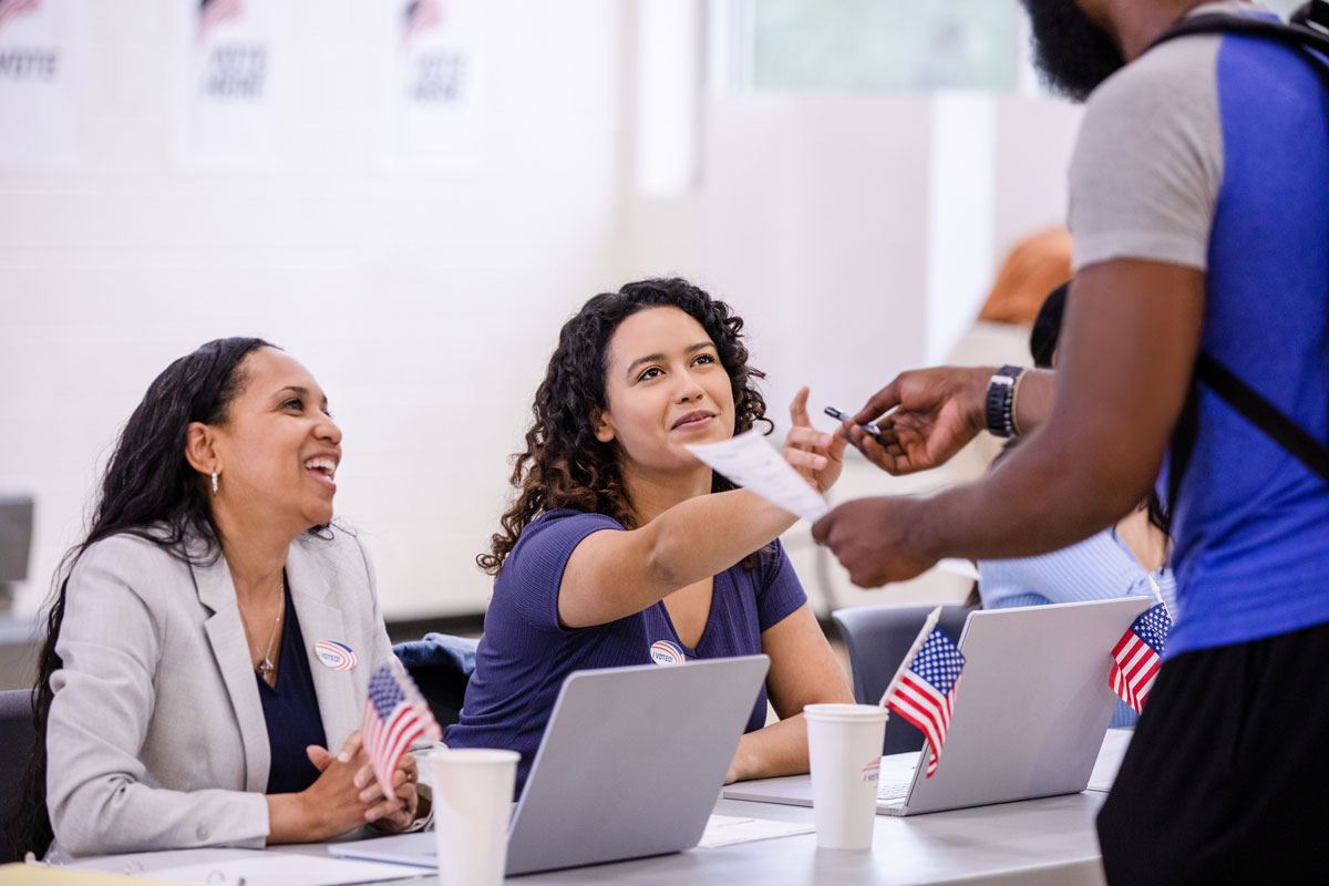 Photo of female poll workers assisting voters.